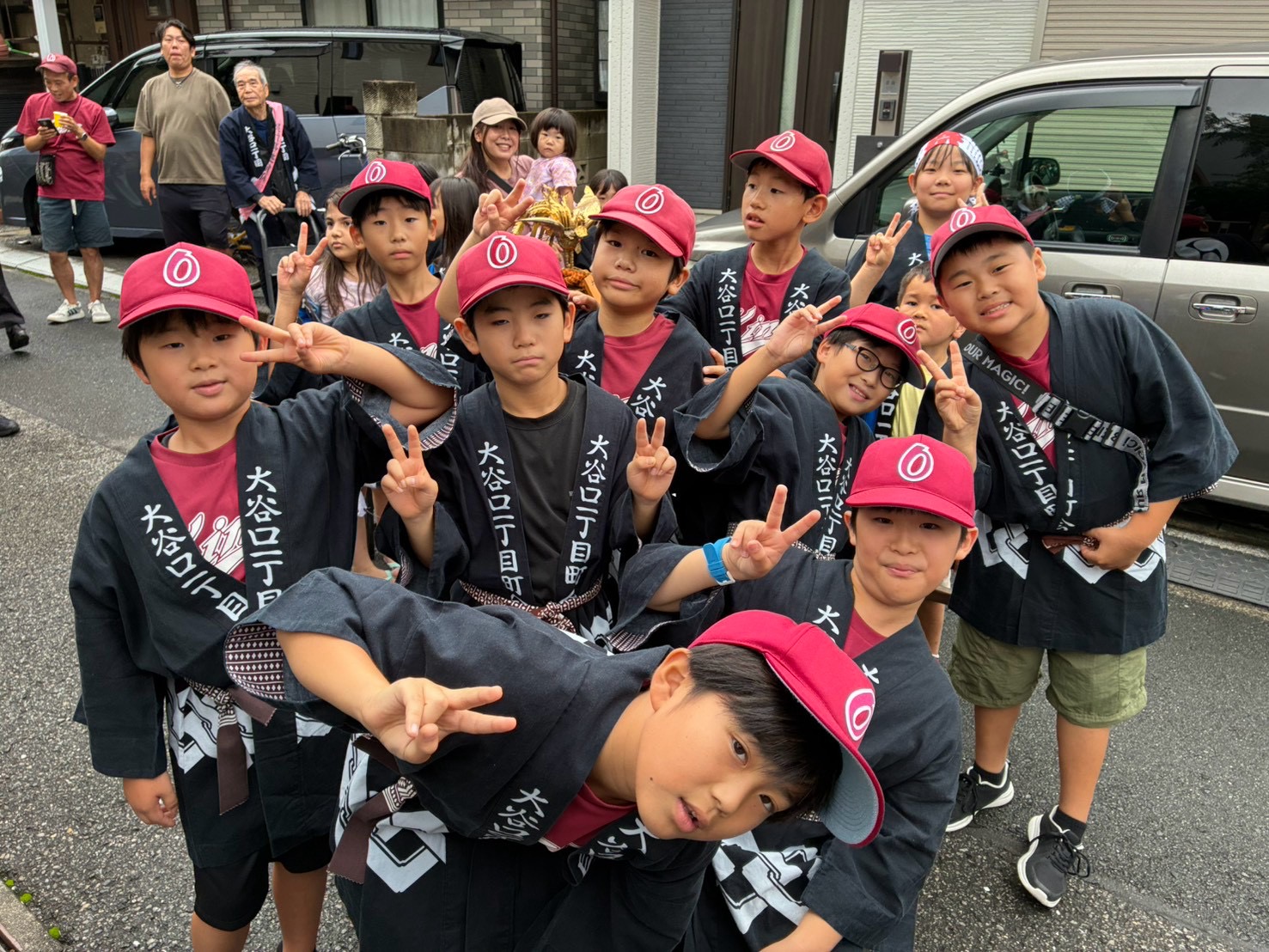 えんじ色の帽子と法被姿で地域のお祭りに参加した大二キングスの子どもたち